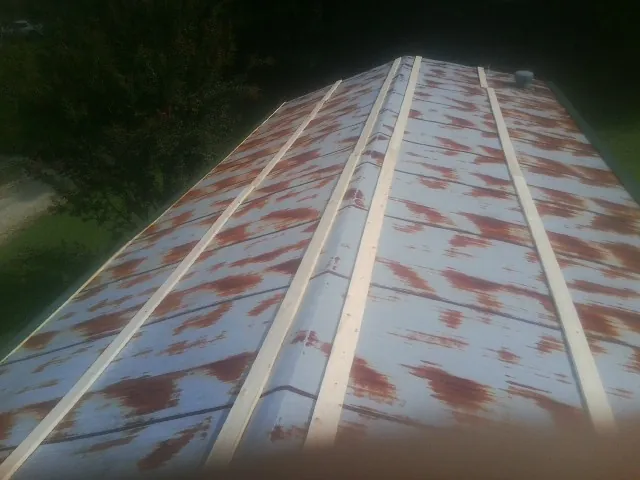 Rusted metal roof panels with new wood purlins before replacement — Storm Damage Roof Repair in Funston by Roofing Brothers